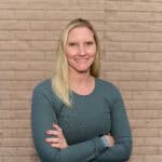 Remembered for her contributions Portrait of Carole Herzog, a woman with blonde hair, smiling, wearing a teal sweater.