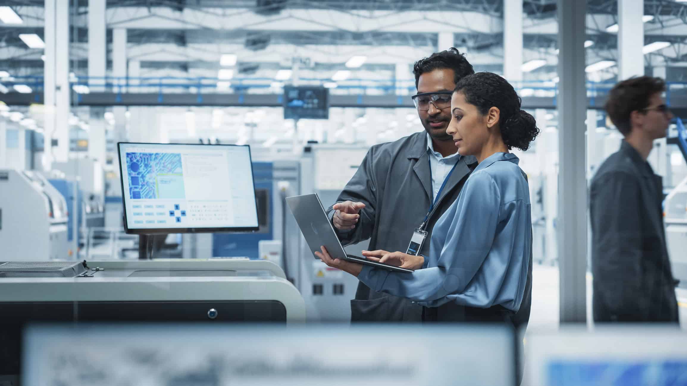 Highly skilled engineers collaborating with digital devices in a modern industrial setting.